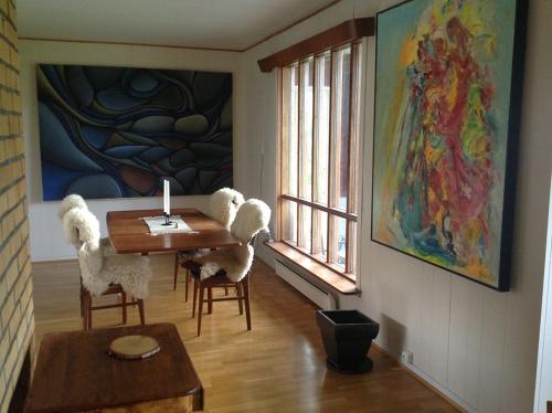 苏特兰Bø Huset的一间带桌椅和绘画的用餐室