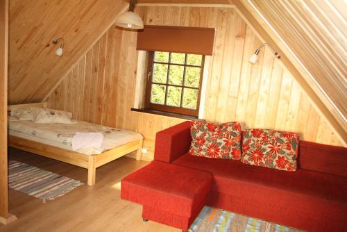 ČornajaAtpūtas komplekss " Ezerkrasti"的一间设有红色沙发、一张床和一个窗户的房间