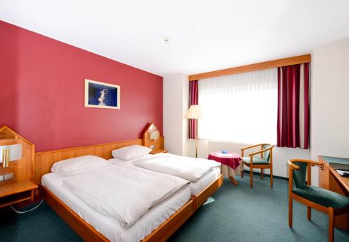 卢森堡克里斯托夫克伦姆的酒店客房,设有床铺和红色的墙壁