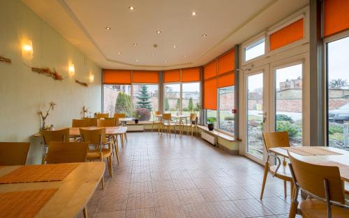 利耶帕亚Hotel Linda - Helvita的餐厅设有桌椅和大窗户。