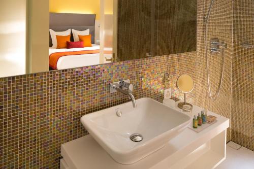 巴塞尔酒店D - 设计酒店的一间带水槽的浴室和一间带一张床的卧室