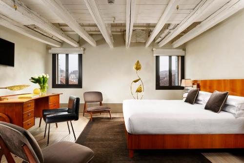 威尼斯Hotel L'Orologio - WTB Hotels的卧室配有一张床、一张桌子和椅子