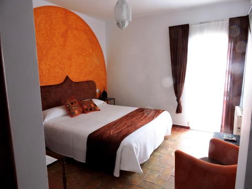 阿尔科斯-德拉弗龙特拉拉方达德尔卡利酒店的一间卧室配有一张大床和一把椅子