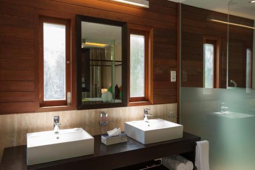 拉迪格岛休闲豪华山林小屋酒店的浴室设有2个水槽和镜子