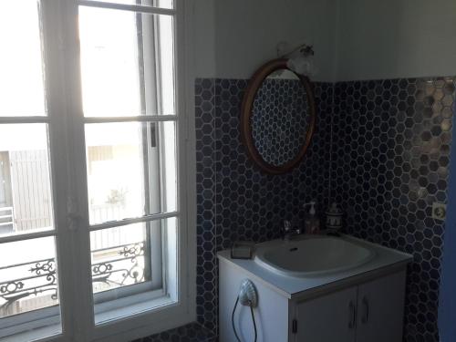 滨海巴纽尔斯Rue sebastien spacious apartment close beach的一间带水槽和镜子的浴室以及窗户。