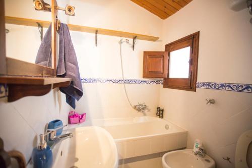 切法卢Bilocale Mandralisca的一间带水槽、浴缸和卫生间的浴室