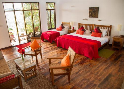 Madawala吉姆农场别墅酒店的一间卧室配有两张床和一张桌子及椅子