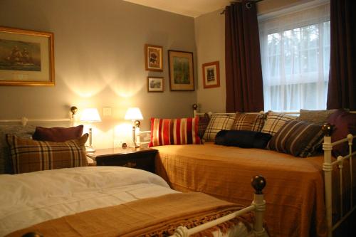 韦斯特伯里马与马夫住宿加早餐旅馆的一间卧室设有两张床和窗户。