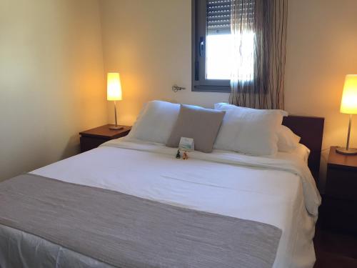 厄尔梅达诺Villa Tejita的一间卧室配有一张带两盏灯的大型白色床。