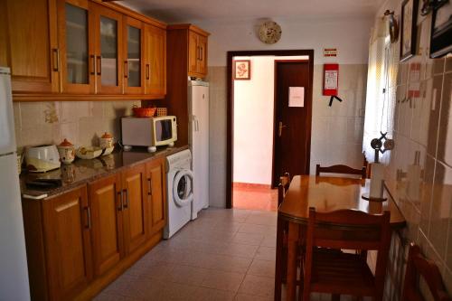 圣地亚哥-杜卡森Monte da Vinha Nova的厨房配有桌子和微波炉