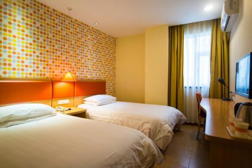 石家庄如家快捷酒店石家庄中山西路金鼎公寓店的酒店客房设有两张床和一台平面电视。