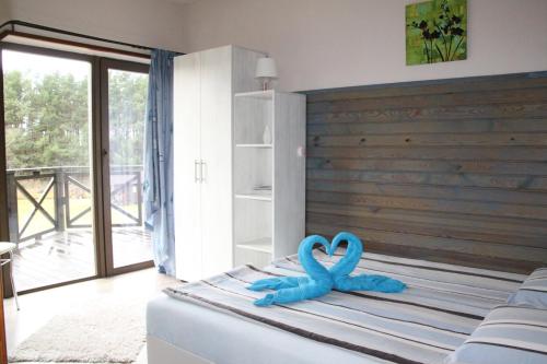 PērkoneVērbeļnieki的一间卧室配有一张带2条蓝色毛巾的床