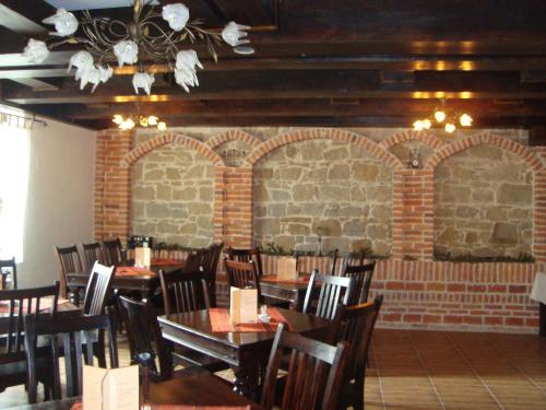 锡盖图马尔马切伊伊乌卡之家旅馆的一间设有桌椅的用餐室和砖墙
