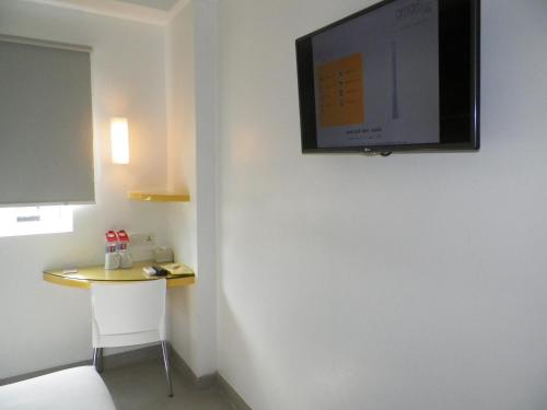 日惹日惹爱玛瑞丝马里奥波罗酒店的客房设有一张小桌子和一台壁挂式平面电视。