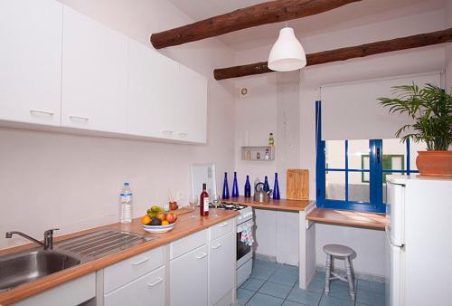 塞博河畔卡莱塔Casa del Rio的厨房配有白色橱柜、水槽和柜台。