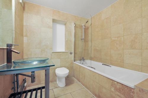 伦敦进入城市公寓的带浴缸、卫生间和盥洗盆的浴室