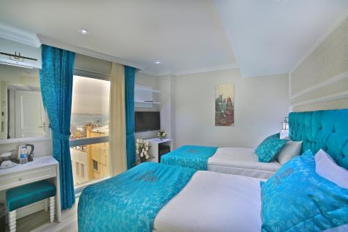 伊斯坦布尔Glamour Hotel Istanbul Sirkeci的酒店客房设有两张床和窗户。
