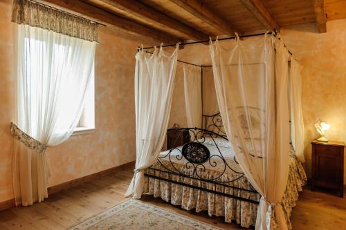 代森扎诺-德尔加达普雷塞列农舍乡村民宿的一间卧室设有天蓬床和2个窗户