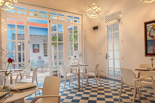 圣玛尔塔Placita Vieja Hotel Boutique Spa的餐厅设有桌椅和窗户。