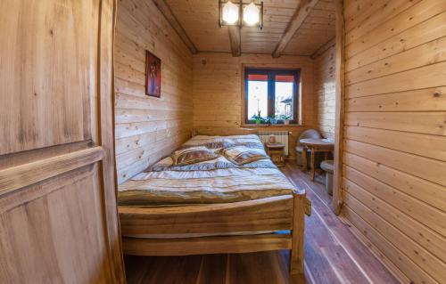 下乌斯奇基Domek Marców的小木屋内一间卧室,配有一张床
