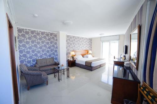 伯利恒伯利恒酒店的一间卧室配有一张床、一张沙发和一把椅子