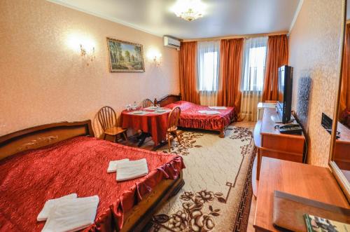 梁赞Briz Hotel的酒店客房设有两张床和一张桌子。