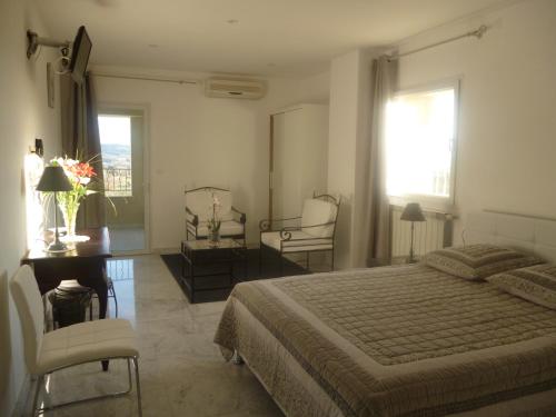 茹卡拉贝格里酒店的卧室配有一张床、一张桌子和椅子