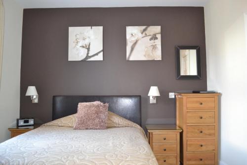 哈罗盖特Geminian的卧室配有一张床,墙上有三幅照片
