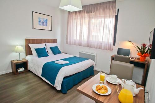 图尔图尔奥达利城市莱特雷斯花园酒店的一间卧室配有一张床和一张带一盘食物的桌子
