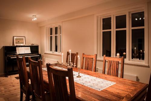 Kolkuós Kolkuós Guesthouse的一间带桌子和钢琴的用餐室