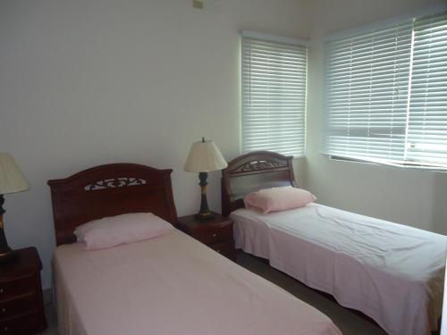 普拉亚布兰卡Balcones -Torre IV的一间卧室设有两张床和窗户。