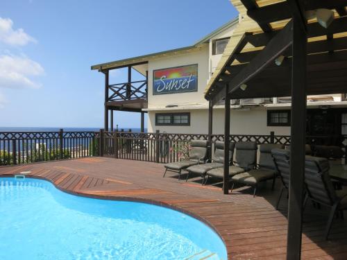 飞鱼湾日落酒店的一座带游泳池和椅子的度假村和一座建筑
