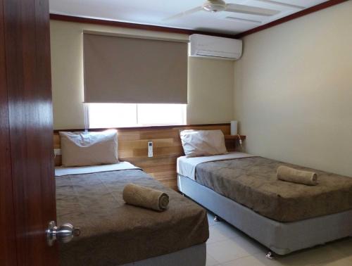 飞鱼湾科科斯帕当山林小屋公寓的酒店客房设有两张床和窗户。