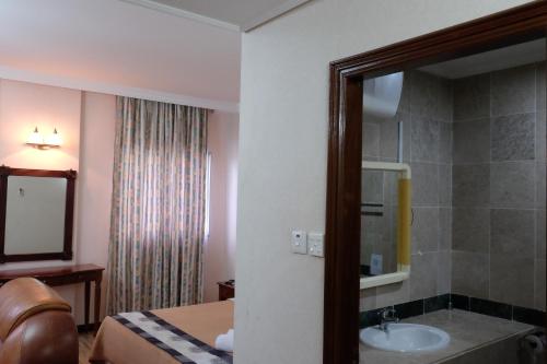 甘榜杰鲁登约鲁顿酒店的一间带水槽、床和镜子的浴室