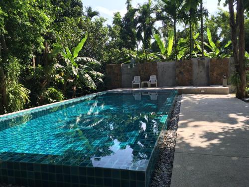 查龙费恩之屋休闲酒店的后院的蓝色瓷砖游泳池