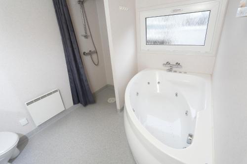 福堡First Camp Bøjden Strand的白色的浴室设有浴缸和窗户。