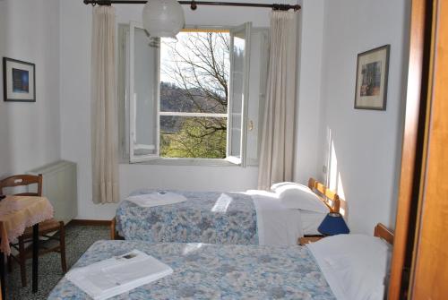 GuigliaLa Lanterna di Guiglia的客房设有两张床和窗户。