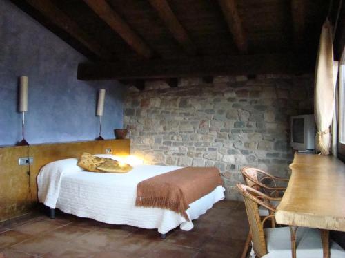 圣洛伦索-德莫鲁尼斯蒙尼高尔酒店的一间卧室设有一张床和石墙