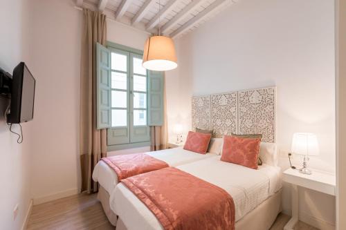 格拉纳达帕拉西奥卡布雷拉利洛公寓的一间卧室设有一张大床和一个窗户。