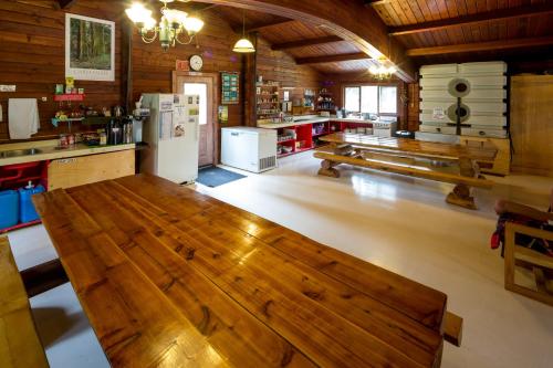 贾斯珀HI Athabasca Falls - Hostel的一间大客房,厨房内配有木桌