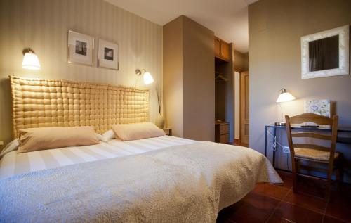 圣马丁-德尔平波Hotel Rural El Yantar de Gredos的一间卧室配有一张大床和一把椅子