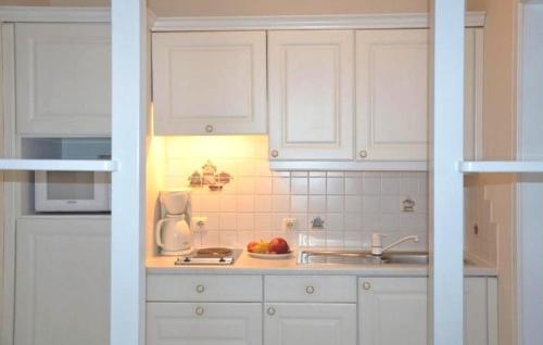 蒂罗尔州圣约翰格劳施鲁索公寓的厨房配有白色橱柜和一碗水果