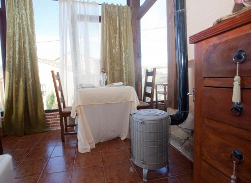 圣马丁-德尔平波Hotel Rural El Yantar de Gredos的一间带桌子和加热器的用餐室