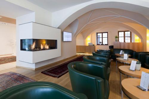 因斯布鲁克马克西米利安彭茨市政厅酒店的一间设有椅子和壁炉的等候室