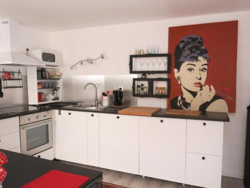 多维尔舒适精装公寓的厨房墙上挂着一幅女人的画