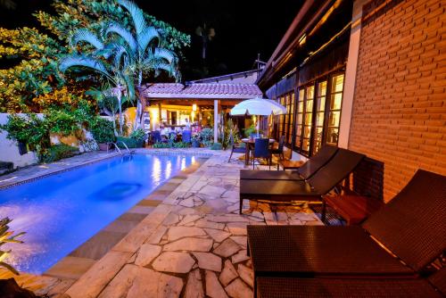 乌巴图巴艾斯特拉格慕卡萨格兰德波萨达酒店的房屋旁的游泳池配有椅子和遮阳伞