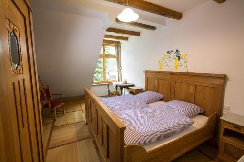 瓦伦多夫舒尔茨奥斯特霍夫酒店的一间卧室配有一张带紫色枕头的木床