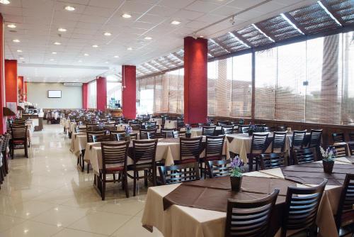 伊达贾伊伊塔雅伊季节101酒店的大型用餐室配有桌椅