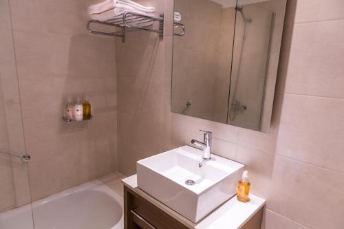 布宜诺斯艾利斯Dazzler by Wyndham Polo的浴室配有盥洗盆、镜子和浴缸