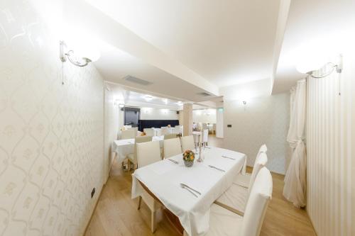 大特尔诺沃单间公寓酒店的白色的用餐室配有白色的桌椅